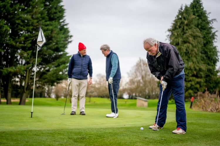 elderly men playing golf